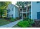 Inviting exterior view of a condo with lush landscaping and charming curb appeal with two palm trees in the center at 401 S Elgin Ct # 401, Charleston, SC 29414