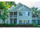 Exterior view of a condo building featuring screened porches and lush landscaping at 401 S Elgin Ct # 401, Charleston, SC 29414