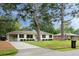 White brick home with well-kept lawn, mature trees, attached carport, and a mailbox at 403 Wedgewood St, Charleston, SC 29407