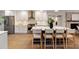 Modern kitchen featuring an island with bar stools, white cabinets, stainless steel appliances, and tile backsplash at 403 Wedgewood St, Charleston, SC 29407