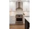 Modern kitchen featuring white cabinets, stainless steel appliances, and a stylish range hood at 403 Wedgewood St, Charleston, SC 29407