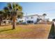 Large backyard with lush lawn, picnic table, tall palm trees, and privacy fence, ready for outdoor fun at 405 Palmetto Blvd, Edisto Island, SC 29438