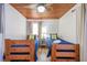 Comfortable bedroom with custom wood ceiling, featuring two twin beds, soft natural lighting and tile flooring at 405 Palmetto Blvd, Edisto Island, SC 29438