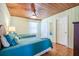 Comfortable bedroom with two twin beds, wooden accents, a ceiling fan, and ample natural light at 405 Palmetto Blvd, Edisto Island, SC 29438