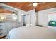 Bedroom with wood ceiling, dresser, walk in shower and access to bed with white bedding at 405 Palmetto Blvd, Edisto Island, SC 29438