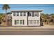A charming two-story home with black shutters, and lush trees at 405 Palmetto Blvd, Edisto Island, SC 29438