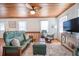 Comfortable living room with a green sofa, wooden accents, a ceiling fan, and a rustic TV stand at 405 Palmetto Blvd, Edisto Island, SC 29438