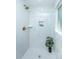 Modern shower with white marble tile, bronze shower head, pebble floor, and window at 4233 Oakridge Dr, North Charleston, SC 29418