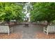 Picturesque community area with a fire pit, benches, mature shade trees, and lush green landscaping at 4953 W Liberty Park Cir, North Charleston, SC 29405