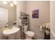 Cozy powder room with pedestal sink, decorative shelving, and a modern accent wall at 4953 W Liberty Park Cir, North Charleston, SC 29405