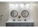 Well-lit bathroom with a double sink vanity, round mirrors, and modern fixtures at 508 Glady Rd, Moncks Corner, SC 29461