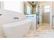 Modern bathroom with freestanding tub, glass shower, marble floors, and window at 54 Summer Dr, Walterboro, SC 29488