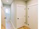 Hallway featuring multiple white doors, wooden floors, and neutral wall paint at 54 Summer Dr, Walterboro, SC 29488