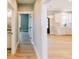 Bright hallway with hardwood floors leads to the kitchen with white cabinets, stainless appliances, and quartz countertops at 54 Summer Dr, Walterboro, SC 29488