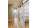 Hallway with a sliding barn door and wood floors at 54 Summer Dr, Walterboro, SC 29488