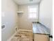 Well-lit laundry room with tile flooring, counter space, and shelving for storage at 54 Summer Dr, Walterboro, SC 29488