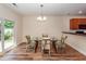 Bright dining area with a glass table, modern chandelier, and door leading to outdoor space at 611 Grassy Hill Rd, Summerville, SC 29483