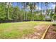 Large backyard with a mix of grass and natural areas, bordered by a privacy fence and mature trees at 6190 Button Bush Dr, Ravenel, SC 29470