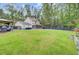 Large backyard featuring a well-maintained lawn, patio, outdoor grill, and privacy fence surrounded by trees at 6190 Button Bush Dr, Ravenel, SC 29470