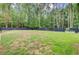 Expansive fenced backyard offers plenty of room for activities and gardening surrounded by trees at 6190 Button Bush Dr, Ravenel, SC 29470