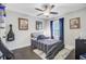 Cozy bedroom with ceiling fan, dark floors, and striped bedding at 6190 Button Bush Dr, Ravenel, SC 29470