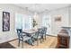 Light-filled dining room with blue wood table and chairs, large window and light fixture at 6190 Button Bush Dr, Ravenel, SC 29470