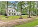 Charming two-story home with a welcoming front porch and lush green lawn surrounded by mature trees at 6190 Button Bush Dr, Ravenel, SC 29470