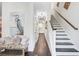 Bright foyer features hardwood floors, staircase with dark treads, and elegant decor, creating a welcoming atmosphere at 6190 Button Bush Dr, Ravenel, SC 29470
