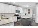 Well-lit kitchen with white cabinets, stainless appliances, and a gray kitchen island at 6190 Button Bush Dr, Ravenel, SC 29470