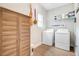 Functional laundry room with washer, dryer, storage cabinet, and open shelving at 6190 Button Bush Dr, Ravenel, SC 29470
