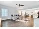 Open-concept living area featuring hardwood floors, a ceiling fan, and seamless flow to the dining and kitchen spaces at 6190 Button Bush Dr, Ravenel, SC 29470