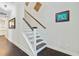 Staircase with hardwood flooring, white risers, and stained railing at 6190 Button Bush Dr, Ravenel, SC 29470