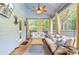 Bright, cozy sunroom with stylish sofas, a wood table, and large windows to the backyard at 6190 Button Bush Dr, Ravenel, SC 29470