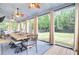 Enclosed patio with dining and lounge areas with ceiling fans and exterior views at 6190 Button Bush Dr, Ravenel, SC 29470