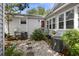 Landscaped backyard featuring a stone pathway, well-maintained AC units, and mature plantings at 647 Ellis St, Mount Pleasant, SC 29464