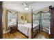 Inviting bedroom features a four-poster bed, hardwood floors, and warm, neutral wall colors at 647 Ellis St, Mount Pleasant, SC 29464