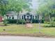 Charming home with a well-manicured lawn, mature trees, and a welcoming front porch at 647 Ellis St, Mount Pleasant, SC 29464