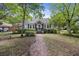 Charming home with a brick pathway, well-maintained lawn, and mature trees, offering a warm and inviting curb appeal at 647 Ellis St, Mount Pleasant, SC 29464