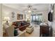 Comfortable living room featuring a leather sofa and bright decor, leading to the dining area at 647 Ellis St, Mount Pleasant, SC 29464
