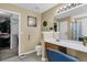 Well lit bathroom with large mirror over vanity, seat, toilet and doorway to walk-in closet at 67 Regency Oaks Dr, Summerville, SC 29485