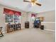 Spacious bonus room with a ceiling fan, large windows, a desk area, and custom shelving for storage at 67 Regency Oaks Dr, Summerville, SC 29485