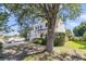 Side view of two-story home with black shutters, showcasing a lush yard and mature tree at 67 Regency Oaks Dr, Summerville, SC 29485