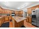Custom kitchen boasts wood cabinets, stainless refrigerator, and unique lighting fixtures at 6840 Early Jersey Rd, Meggett, SC 29449
