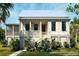 Charming coastal home featuring a white exterior, inviting front porch, and lush tropical landscaping at 7059 Sounding Ln, Johns Island, SC 29455