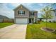 Inviting two-story home with a two-car garage, green lawn, and charming curb appeal at 716 Mcroy St, Moncks Corner, SC 29461