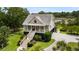 Aerial shot of charming home in a lush, green setting with a long stair case and red front door at 8964 Palmetto Rd, Edisto Island, SC 29438