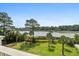 Expansive backyard with lush lawn, palm trees, and serene water views at 8964 Palmetto Rd, Edisto Island, SC 29438
