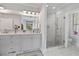 Bright bathroom with marble floors, a double vanity, and frameless glass shower at 8964 Palmetto Rd, Edisto Island, SC 29438