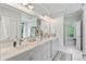 Bright bathroom with double vanity, marble countertop, large mirror, and walk-in shower at 8964 Palmetto Rd, Edisto Island, SC 29438