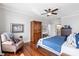 Bright bedroom featuring hardwood floors, area rug, ceiling fan, and ensuite bathroom access at 8964 Palmetto Rd, Edisto Island, SC 29438